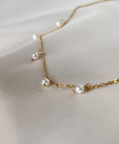 The Celeste necklace is the perfect piece of jewelry to elevate any look. Featuring nine lustrous fresh water pearls in a soft gold-plated chain, it adds a touch of elegance and luxury to any outfit. Perfect for layering with other pieces or wearing on its own for a subtle statement. -Composed of- Stainless steel 18k Gold plating Freshwater pearls hypoallergenic tarnish free - Measurements- 16" +2" extension All our pearls at Flourré are real fresh water pearls, making every piece unique in shap Pearl White Pearl Necklace With Chain, Gold Chain Necklace With Pearl Pendant For Party, Party Gold Chain Necklace With Pearl Pendant, Gold Pearl Choker With Clavicle Chain, Gold Pearl Clavicle Chain Choker, Gold Pearl Choker With Delicate Chain, Chic Pearl Chain Necklace With Delicate Design, Gold Delicate Chain Pearl Choker, Gold Pearl Choker Necklace With Delicate Chain