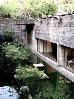 an image of a building that is made out of concrete and has plants growing on it