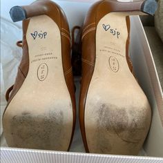 a pair of brown shoes in a box with the label voip on one shoe