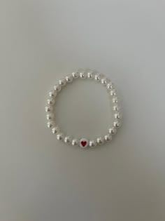 This bracelet is simple yet stylish with a heart bead with pearls around it! Braclets Beads Aesthetic, Cheap Trendy Heart Bracelet With Round Beads, Simple Beads Bracelets Ideas, Pearls Bracelet Ideas, Aesthetic Pearl Bracelet, Casual White Pearl Bracelets, Heart-shaped Beaded Pearl Bracelet Gift, Elegant Pearl Heart Bracelet With Charm, Elegant Heart-shaped Pearl Bracelets