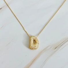 Elevate your jewelry collection with our Crystal Bubble Initial Necklace. Adorned with sparkling crystals, this versatile piece adds a touch of elegance and personalization to any outfit. 16" with a 2" extender, made of 18k gold plated brass, lead, and nickel-free. Make a statement, wear it alone or layer it with other accessories. Gold-plated Crystal Necklace, Gold Cubic Zirconia Drop Necklace Gift, Gold Plated Necklaces With Pave Setting For Gift, Elegant Gold Crystal Charm Necklaces, Gold Teardrop Pave Jewelry, Gold Plated Pave Setting Necklace For Gift, Gold Teardrop Jewelry With Pave Setting, Gold Teardrop Pave Set Jewelry, Gold Crystal Necklace With Adjustable Chain