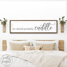 a bedroom with a bed and two planters on the wall above it that says, we should probably probably cuddle