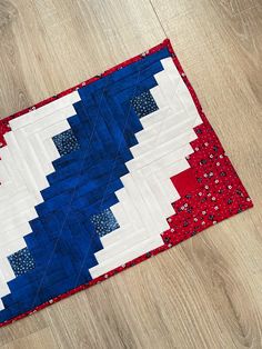 a red, white and blue quilt is laying on the floor