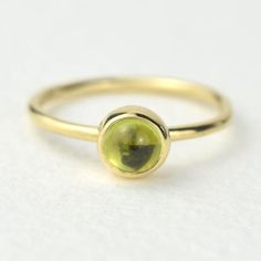 A stunning green peridot stacking ring made from solid 9ct yellow gold. Choose to wear the ring on its own, or mix and match it with other stacking rings from the Nebula collection, or why not add a sparkling Andromeda diamond ring?Peridot is a beautiful juicy green gemstone and the birthstone of August. It is one of only a few stones to come in only one colour, a lovely olive green and is said to bring a wonderful year to whoever wears it. It's warm glowing colour is a reminder of summer and of Yellow Gold Peridot Round Rings, Stackable Yellow Gold Peridot Jewelry, Stackable Round Peridot Jewelry, Gold Peridot Birthstone Ring, Yellow Gold Peridot Stackable Rings, 14k Gold Green Solitaire Stackable Rings, Green Solitaire Stackable Rings In 14k Gold, Green Stackable Birthstone Ring With Round Shape, Green Stackable Birthstone Ring Round