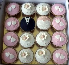 a box filled with lots of cupcakes covered in white and pink frosting