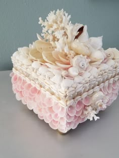 a decorative box with seashells and flowers on it