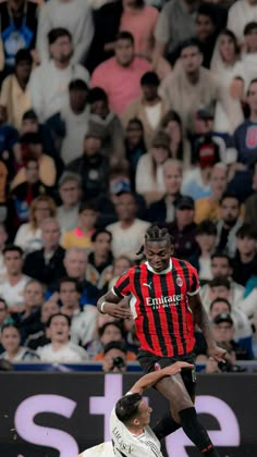 two men playing soccer in front of an audience