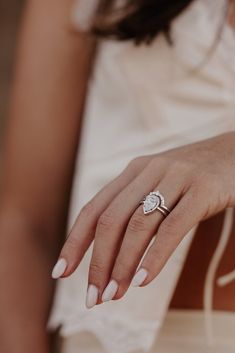 a close up of a person wearing a ring on their finger and holding her hand