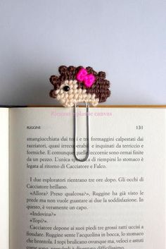 an open book with a small crocheted animal on it's back end