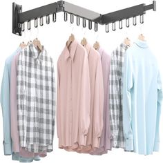 three shirts hanging on clothes racks with coat hangers in front of them, and one is