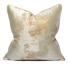 a gold and white pillow on a white background