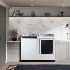 a washer and dryer in a kitchen with marble counter tops on the wall