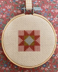 a cross stitch pattern on a wooden hoop