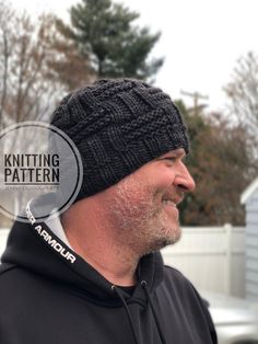 a man wearing a black knitted hat with the knitting pattern on it's side