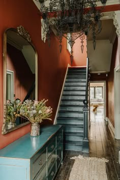 a blue dresser sitting in front of a staircase