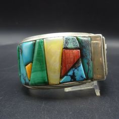 "VINTAGE ANDREW ALVAREZ BRACELET DESCRIPTION: This outstanding cuff is from celebrated artisan Andrew Alvarez. Extremely heavy gauge sterling silver is adorned with cobblestone inlay of turquoise, malachite, spiny oyster shell, and mother of pearl. This exquisite bracelet will be a cherished addition to your collection of fine vintage Southwest and Native American jewelry. MEASUREMENTS: Interior of the cuff measures 5 1/2\" with an additional 1 1/8\" non-adjustable gap. Total circumference: 6 5/ Vintage Cuff Bracelet With Natural Stones Gift, Vintage Gemstone Cuff Bracelet, Vintage Gemstone Cuff Bracelet Bangle, Vintage Adjustable Gemstone Cuff Bracelet, Adjustable Vintage Gemstone Cuff Bracelet, Vintage Cuff Bracelet With Natural Stones, Vintage Bangle Cuff Bracelet With Natural Stones, Vintage Natural Stones Cuff Bracelet, Vintage Natural Stones Cuff Bangle