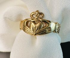 a gold ring with a crown on it sitting on top of a white napkin holder