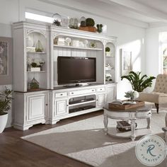 a living room filled with furniture and a flat screen tv on top of a entertainment center