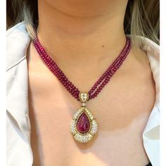 This is part of Chairish’s Fine Jewelry assortment.  This captivating pendant necklace, showcases a mesmerizing 22.41 carat, deep pink ruby cabochon cut, securely set in a classic bezel mounting crafted from 18k yellow gold. The weight of the piece is 27.57 grams. GRS certified, the ruby is surrounded by 144 sparkling diamonds and further complemented by 7 elegant emerald cut diamonds, totalling approximately 13-15 carats. A beaded ruby chain completes this luxurious and unique statement piece. Elegant Ruby Briolette Necklace, Diamond Cabochon Pendant Necklace, Luxury Pear-shaped Ruby Jewelry, Formal Pear-shaped Ruby Necklace, Luxury Cabochon Round Pendant Necklaces, Luxury Cabochon Round Pendant Necklace, Luxury Round Pendant Necklaces With Cabochon, Luxury Round Pendant Necklace With Cabochon, Elegant Cabochon Teardrop Pendant Necklace