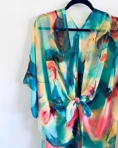 Details Kimono inspired silhouette. All over print. Cut in a loose fit. Semi-sheer and lightweight. Perfect for all occasions. Everyday with jeans and a tank. To a wedding or event over a simple dress. Over PJ's with your bridesmaids while you prepare for your big day. Over a bathing suit at the beach because this is the perfect material as it won't retain sand and will dry ultra fast. Even an outdoor concert or festival with a floral crown and some short shorts :) Content & Care * Silky Polyest Multicolor Printed Wrap Cover-up, Colorful Summer Kimono With Kimono Sleeves, Summer Kimono With Abstract Print, Blue Watercolor Print Tops For Summer, Blue Abstract Print Top For The Beach, Multicolor Printed Cover-up With Kimono Sleeves, Summer Kimono With Abstract Print And Kimono Sleeves, Multicolor Abstract Print Kimono For Beach, Flowy Multicolor Summer Kimono