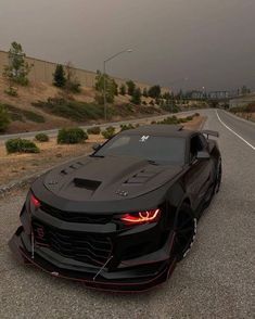 a black sports car is parked on the side of the road