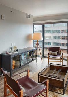 a living room filled with furniture and a large window overlooking the cityscape in front of it