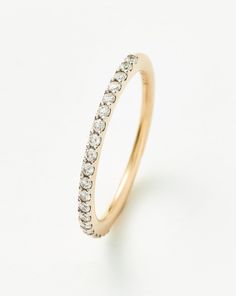 a yellow gold ring with small diamonds on the side, set against a white background