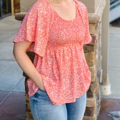 This Peach Colored Smocked Raglan Flutter Sleeve Top Has A Very Romantic Feel To It. Oversized Flowy Sleeves And Babydoll Bottom. However, Keep In Mind That The Smocking Section Of The Top Is Very Tight. Subtle Floral Print On This Peplum V-Neck Top. 100% Polyester Fit Notes: The Tight Smocking Section Is Extremely Gathered So You Will Want To Size Up At Least One Size Summer Tops With Smocked Cuffs And Billowy Fit, Billowy Summer Tops With Smocked Cuffs, Casual Smocked Top With Ruched Ruffle Sleeves, Casual Blouse With Smocked Back And Flutter Sleeves, Casual Blouse With Flutter Sleeves And Smocked Back, Casual Floral Smocked Top With Ruffle Sleeves, Spring Smocked Top With Ruffle Sleeve And Smocked Bodice, Smocked Top With Ruffle Sleeves For Spring, Ruffle Sleeve Smocked Top For Spring