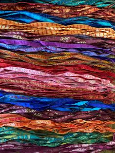 an abstract piece of art made out of different colored fabrics and fabric strips, with the colors