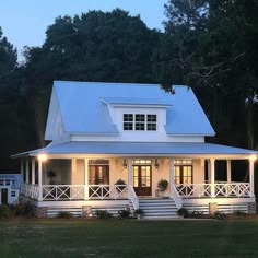 a white house with porches and lights on it