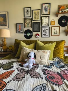 a bed with many pictures on the wall above it and a stuffed dog sitting on top