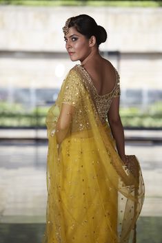 This crowd pleasing mustard net saree with mirror work highlight and scallop border detailing is paired with with our mirror and pearl work blouse. Festive Yellow Pre-draped Saree With Mirror Work, Designer Sheer Dupatta Blouse For Diwali, Gold Bollywood Blouse With Sheer Dupatta, Bollywood Style Gold Blouse With Sheer Dupatta, Anarkali Blouse With Sheer Dupatta For Designer Wear, Designer Blouse With Sheer Dupatta For Navratri, Anarkali Blouse With Gota Work For Eid, Elegant Yellow Saree With Mirror Work, Festive Gold Blouse With Sheer Dupatta