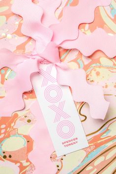 the pink ribbon is tied on top of an abstract background with gold and pink flowers