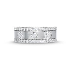 a white gold ring with three diamonds on the side and two rows of stones in the middle