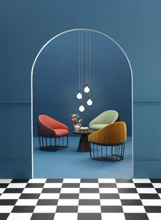 a room with black and white checkered flooring, chairs and a mirror on the wall