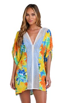 Model is wearing a blue Spring Beach Party Cover-up With Crochet Trim, Beachy V-neck Floral Print Beach Dress, Multicolor V-neck Cover-up For Beach Party, Multicolor V-neck Beach Dress With Floral Print, Vibrant Print V-neck Kaftan For Beachwear, Summer V-neck Cover-up With Tropical Print, Beachy Multicolor V-neck Cover-up, Floral Print V-neck Cover-up For Vacation, Tropical V-neck Kaftan For Beach Cover-up