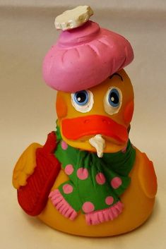 a yellow rubber duck with a pink hat and scarf