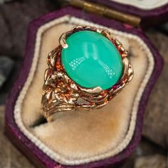 This gorgeous heavily patinated ring features an oval cabochon chrysoprase set with 4 angled prongs atop a freeform gallery. The ring is crafted in 10k yellow gold and is currently a size 6.25. Unique Oval Cabochon Emerald Ring, Heirloom Green Oval Opal Ring, Vintage Green Oval Opal Ring, Vintage Chrysoprase Ring Jewelry, Vintage Chrysoprase Ring, Nature-inspired Green Oval Emerald Ring, Green Oval Cabochon Emerald Ring Collectible, Yellow Gold Emerald Chrysoprase Cabochon Ring, Oval Chrysoprase Opal Ring For Gift