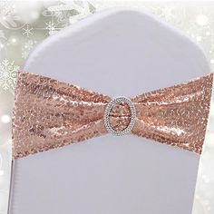 a white chair with a rose gold bow tie on it's back and snowflakes in the background