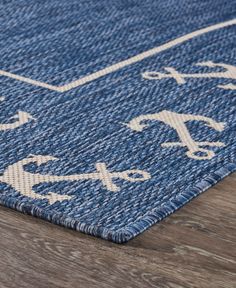 a blue and white rug on top of a wooden floor with an arrow design in the middle