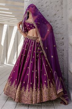 Midnight purple lehenga with gold dori and aari embroidered floral motifs. Paired with blouse and dupatta.
Components:3
Pattern:Embroidery
Type of Work:Dori, aari, floral
Neckline:V neck
Sleeve Length:Half
Fabric:Chiniya silk, organza
Color:Purple
Other Details:
Side tassel tie-up
Embroidered sheer dupatta
Note: Hair accessory worn by the model is not for sale
Occasion:Bride - Aza Fashions Purple And Gold Lehenga, Dark Purple Lehenga, Lehenga Colours, Purple Lehenga, Chic Prom Dresses, Maharani Designer Boutique, Midnight Purple, Bridal Lehenga Online, Desi Attire