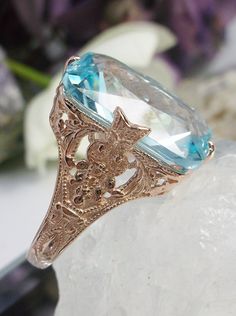 Simulated Aquamarine Rose Gold plated Sterling Silver Ring Treasure Design#D202 This is an Edwardian era reproduction filigree ring. The Art Deco design is beautifully created in rose gold plated solid sterling silver. This is a flawless man-made/simulated sky blue aquamarine that measures 18mm by 13mm. The ring is 3/4" (19mm) North to South on the finger. The inside of the band is etched 925 (sterling). Notice the intricate and detailed floral design. The rose gold 'embraced' silver filigree ac Classic Rose Gold Rings With Intricate Design, Rose Gold Engraved Ring With Intricate Design, Heirloom Rose Gold Filigree Ring In 14k Gold, Ornate Rose Gold Jewelry With Intricate Design, Ornate Rose Gold Filigree Jewelry, Elegant Rose Gold Engraved Ring With Diamond Cut, Elegant Rose Gold Engraved Diamond Cut Ring, Antique Diamond Cut Rose Gold Ring, Antique Rose Gold Diamond Cut Ring