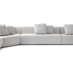 a large white couch with lots of pillows on it's back and side ends