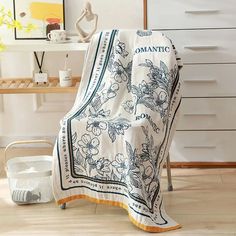 a white and blue blanket sitting on top of a wooden floor next to a basket