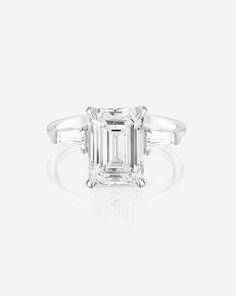 an emerald - cut diamond ring with baguets on the shoulders and side stones