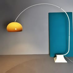 a lamp that is on the side of a wall next to a blue piece of furniture