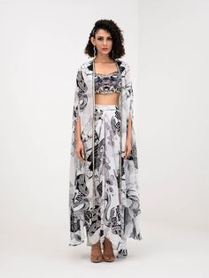 A three-piece Yang Printed Dhoti Skirt Set Paired With Bralette and Cape from the Juhi Bengani collection – Festive 2023. This gorgeous yang printed dhoti skirt is paired with a heavy embroidered yang bralette blouse. The bright black and white prints with floral work, heavy embroidery of mirror, beads, and thread sequence work enhance this crepe dhoti skirt set. This outfit is completed with a yang black and white printed cape with embroidered mirror lace border.
READY TO SHIP Traditional Drape Sets With Digital Print For Reception, Digital Print Sets For Reception With Traditional Drape, Digital Print Choli For Navratri Party, Designer Sleeveless Sets With Printed Motifs, Bollywood Style Sets With Digital Print For Reception, Bollywood Style Sets For Reception With Digital Print, Party Digital Print Choli For Navratri, Sleeveless Sets With Printed Motifs, Digital Print Georgette Lehenga