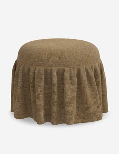 a brown ottoman with a pleated skirt on it's side and the bottom