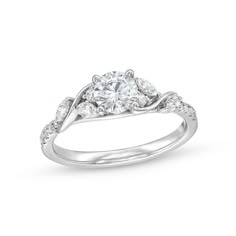 Start your love story with the elegant and charming details of this round diamond cascading vine engagement ring. Crafted in 14K white gold The 5/8 ct. round diamond sparkles at the center. A cascade of marquise-cut and round diamonds shimmers along curved vine-like ribbons. Diamonds line the shank to complete the look. This engagement ring shines with 7/8 ct. t.w. of diamonds. Swirl Diamond Ring, Family Ring, Pretty Engagement Rings, Engagement Rings Twisted, Cute Engagement Rings, Engagement Ring Ideas, Future Engagement Rings, Elegant Engagement Rings, Swirl Ring