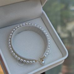 Embrace timeless grace with our Dainty Pearl White Freshwater Bracelet. Featuring delicate 4-5mm pearls, this bracelet captures a classic elegance that's both subtle and enchanting. Perfectly strung to rest effortlessly on your wrist, the small-sized pearls provide a refined touch that's suitable for any occasion. Whether worn alone or paired with other pieces, this dainty bracelet embodies pure sophistication. It's a beautiful reminder that true elegance often lies in simplicity. Pearl size 4-5 Classic Pearl Charm Bangle Bracelet, Pearl White Bangle With Pearl Charm, Pearl White Bangle Bracelet With Pearl Charm, Pearl White Beaded Bracelet With Pearl Charm, Dainty White Gold Pearl Bracelet, Akoya Pearl Bracelets For Anniversary In Pearl White, Pearl White Akoya Pearl Bracelets For Anniversary, Anniversary Akoya Pearl Bracelet In Pearl White, Minimalist Pearl Drop Bracelet For Anniversary